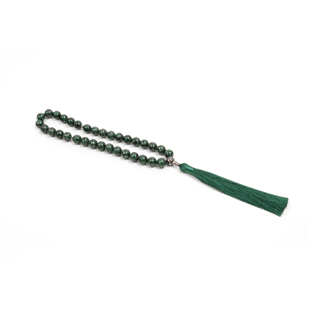 Close-up of green blackwood meditation beads with gold silver leaf lacquer
