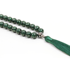 Green beaded necklace with a tassel on a white background