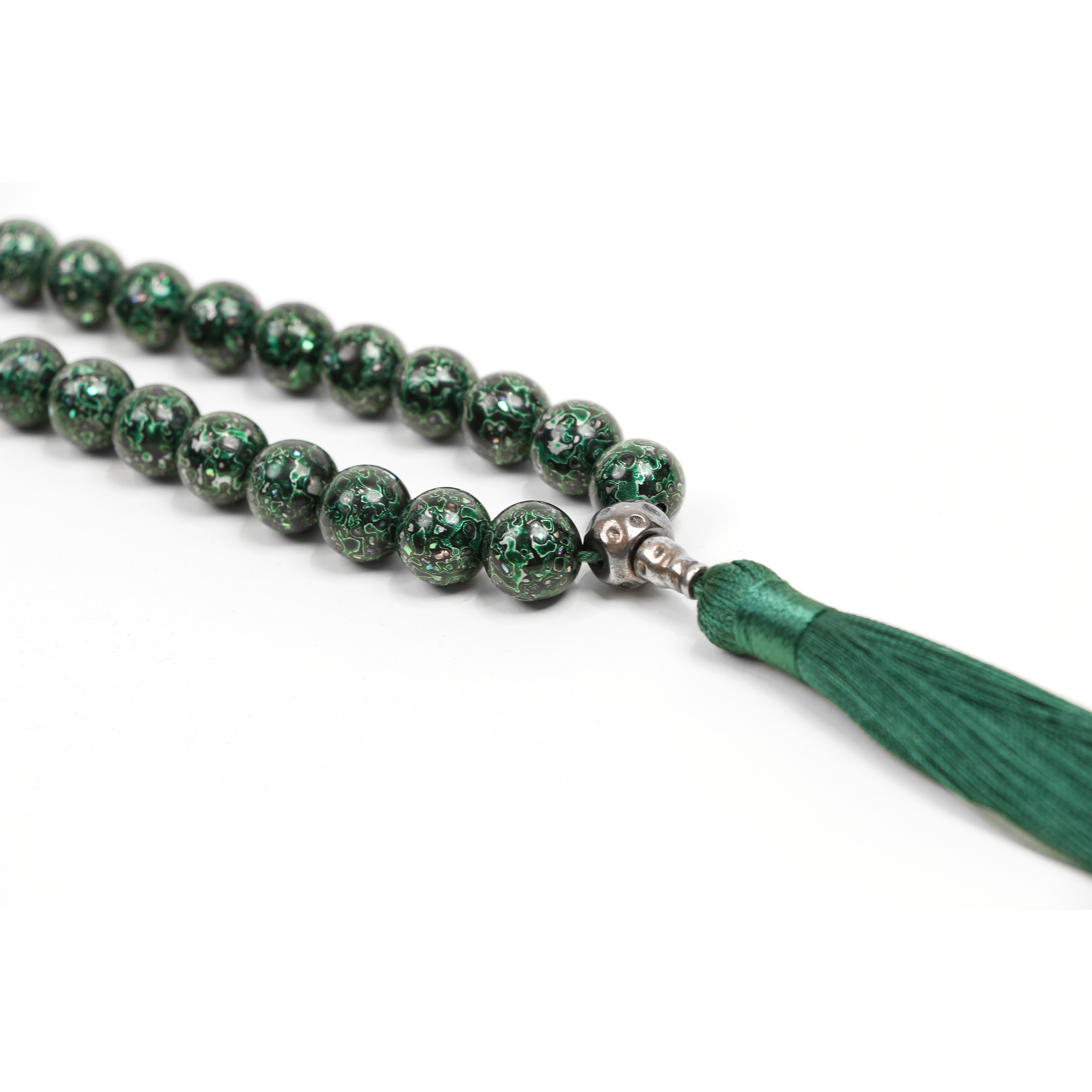 Green beaded necklace with a tassel on a white background