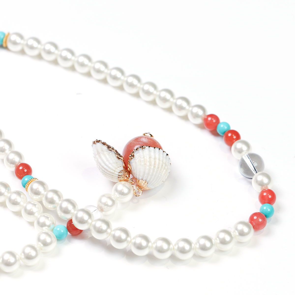 Pearl meditation bracelet with colorful beads and shell charm on a white background