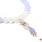 Detail of 33 smooth meditation beads with 925 Silver tassel on wooden surface