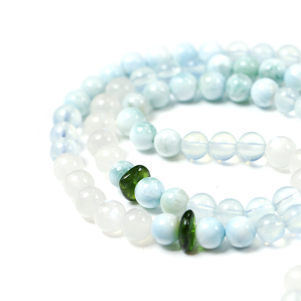 Close-up of 99 smooth crystal beads on Ease + Release meditation bracelet.