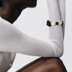 Editorial side view of the Gold | Edge Bracelet worn over a white long-sleeve top, highlighting the unique silhouette of the bead cluster and clear quartz cubes.
