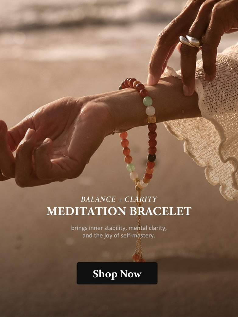 Meditation bracelet being worn on a wrist with a blurred beach background