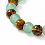 Bracelet with green beads and brown tiger eye stones on a white background
