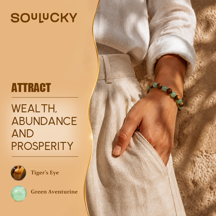 Person wearing a bracelet with text about attracting wealth, abundance, and prosperity using Tiger's Eye and Green Aventurine stones.