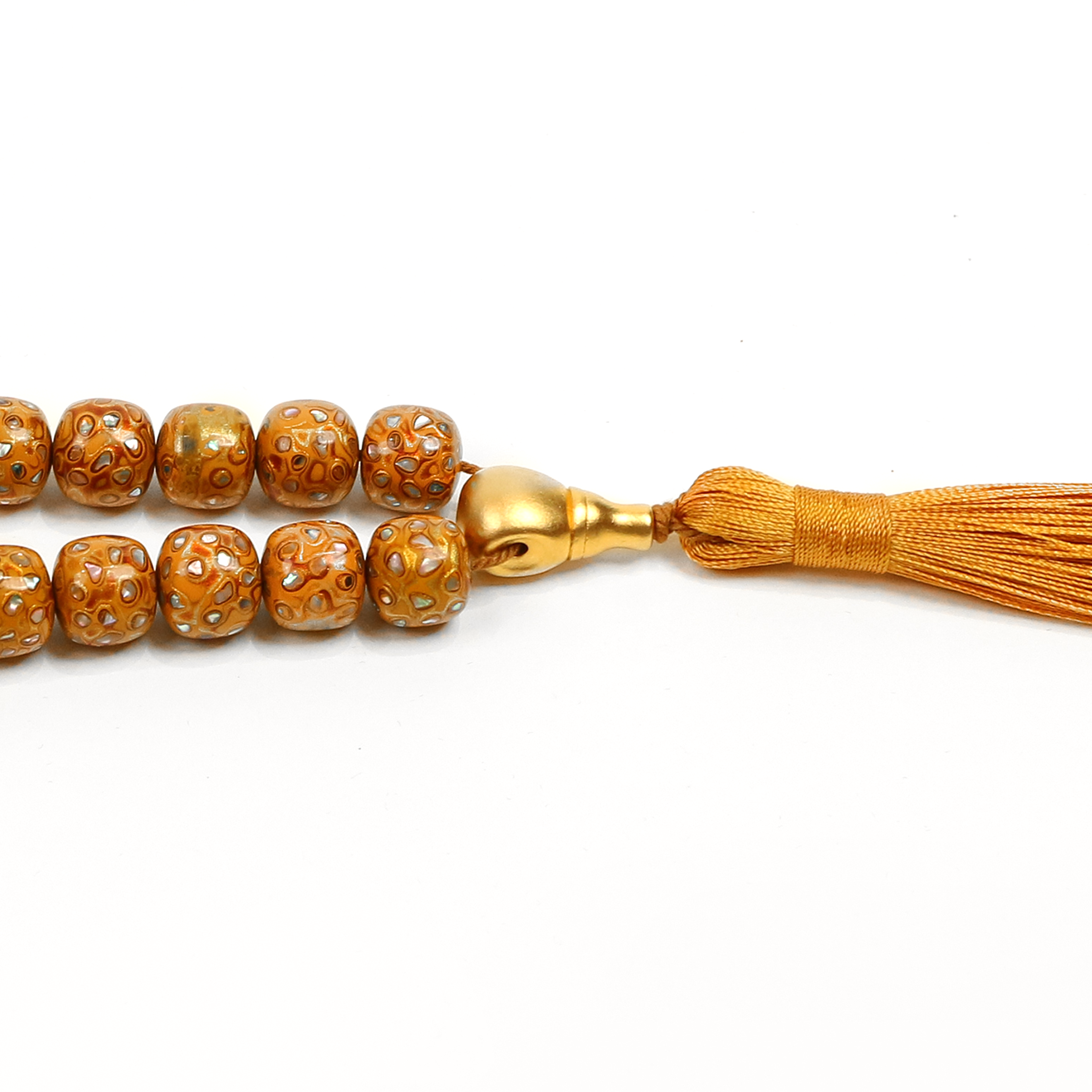 Close-up of a gold beaded meditation bralcelet with tassel on a white background