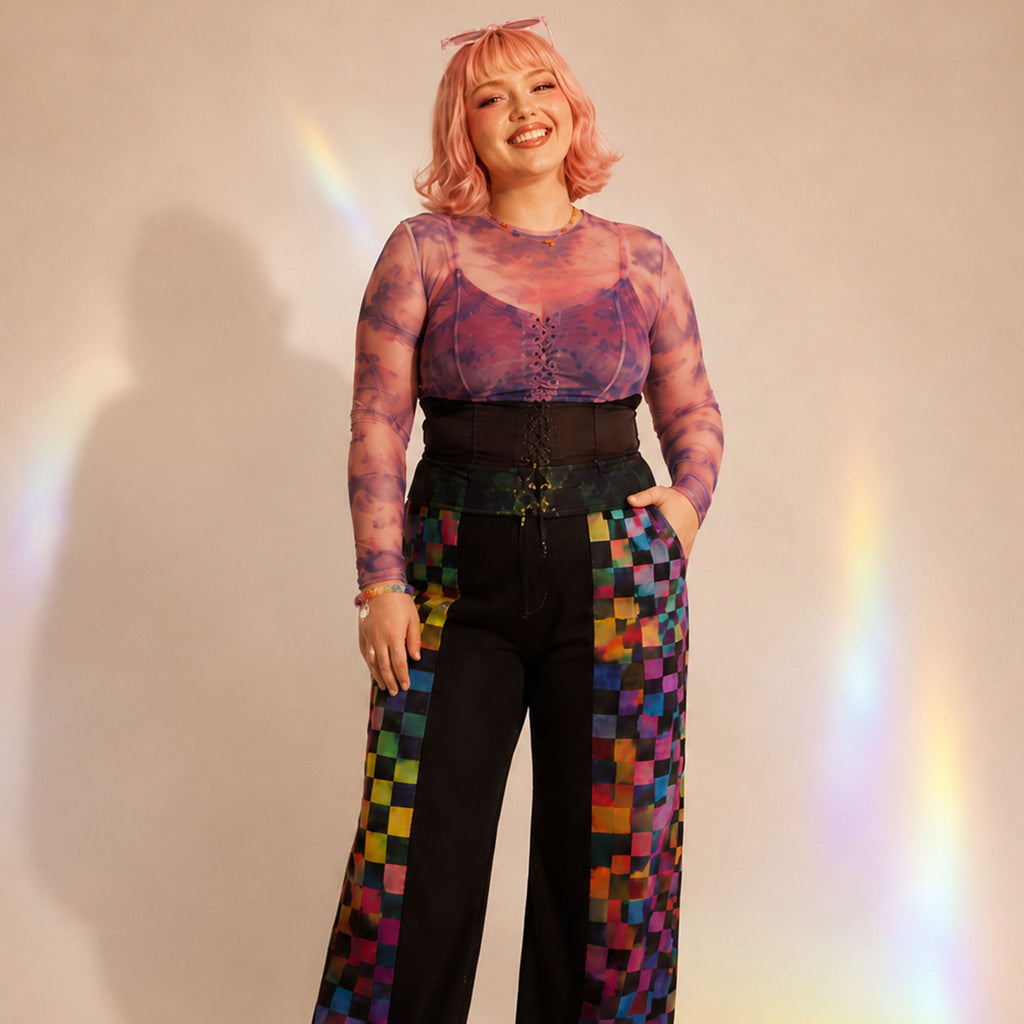 Person wearing a colorful outfit with a checkered pattern on a plain background