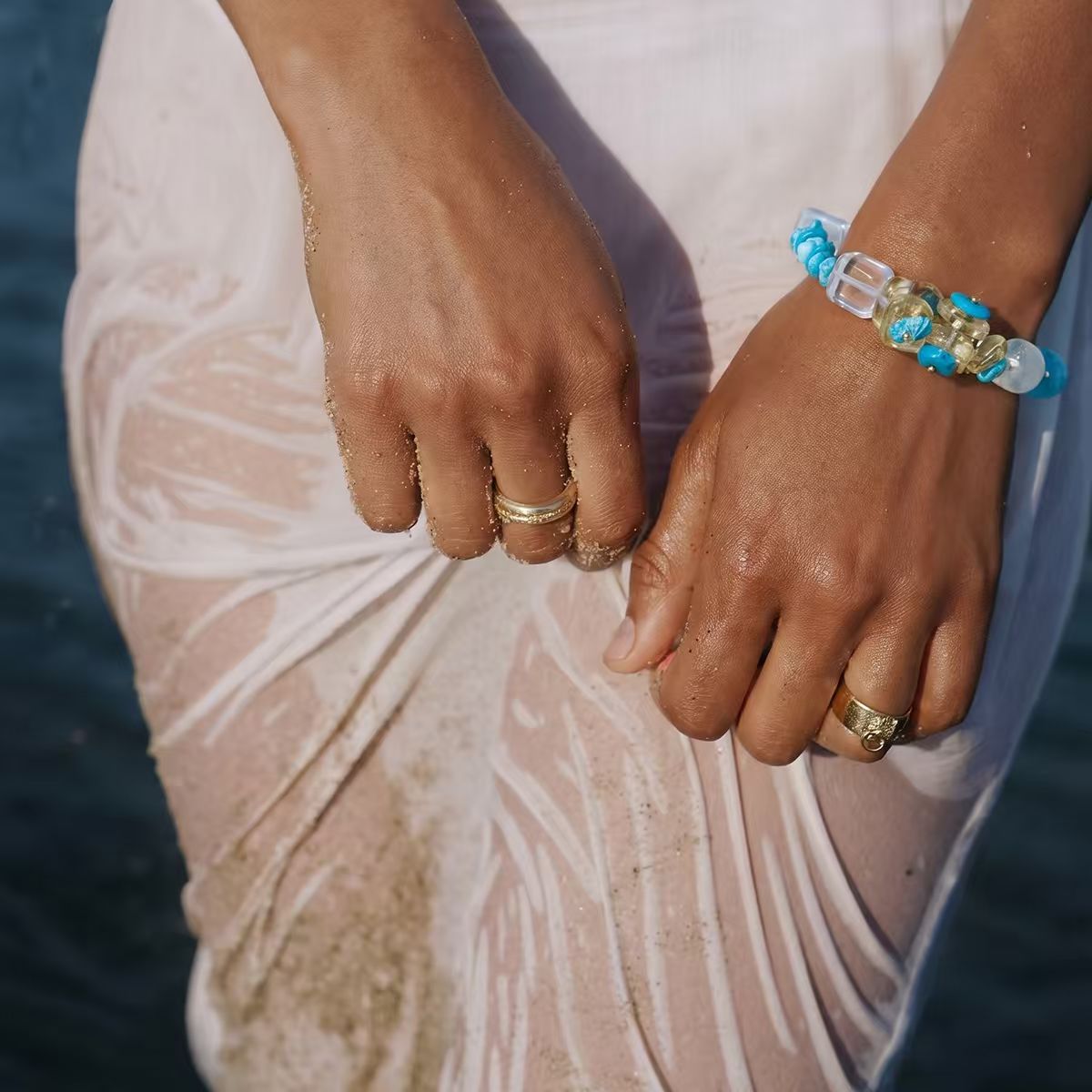 Water | Ease bracelet on model arm in coastal high-fashion setting