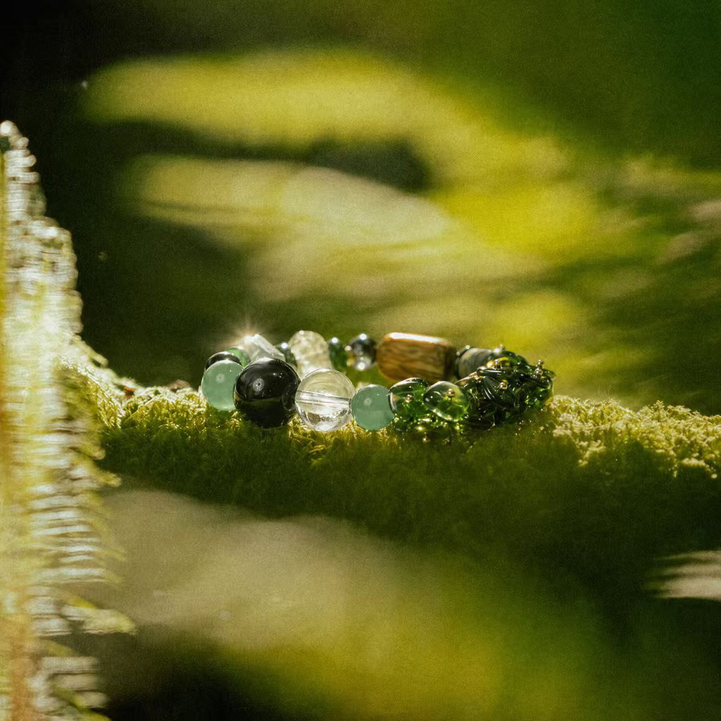 Wood Align bracelet with 7 healing crystals displayed on moss